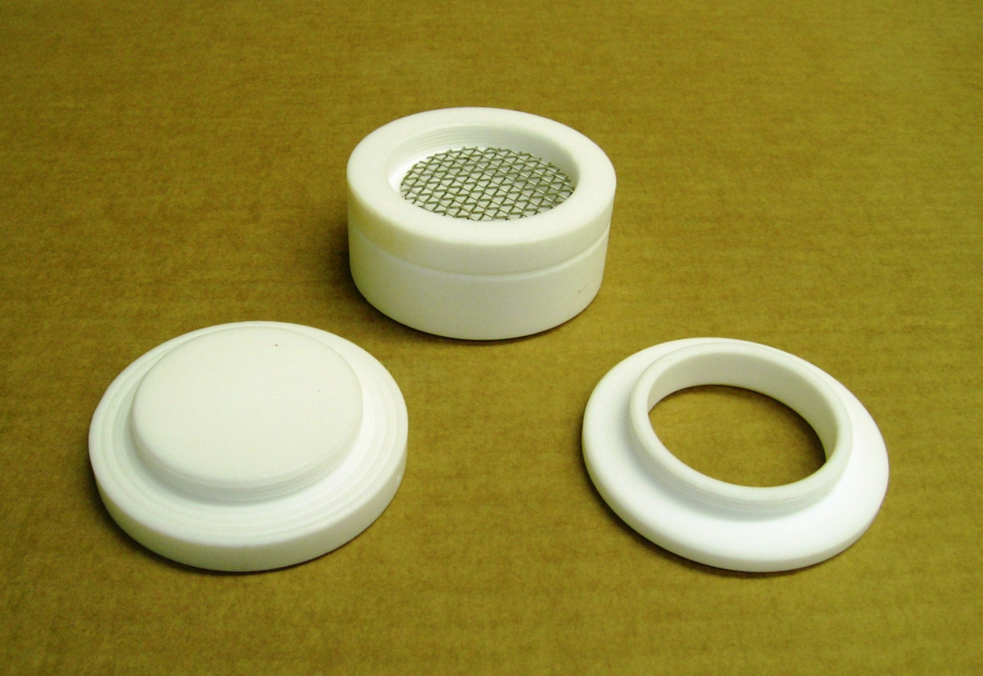 An Empore Disk casing that has been disassembled. The Empore Disk is a small flat disk that goes in this casing